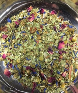 Close-up of a custom herbal tea blend with dried leaves and flower petals by Custom Co-Pak, a private label tea manufacturer in the USA